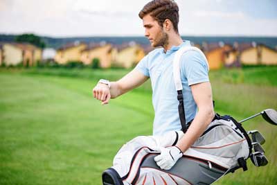 Golfer checking time on watch.