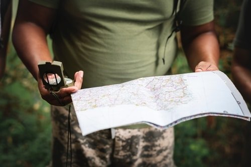 man reading compass and map