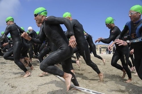 triathletes checking watch at start