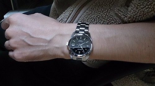 stainless steel watch on mans arm