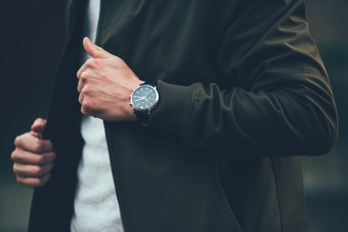 Man in casual clothing flashing an elegant men's wristwatch