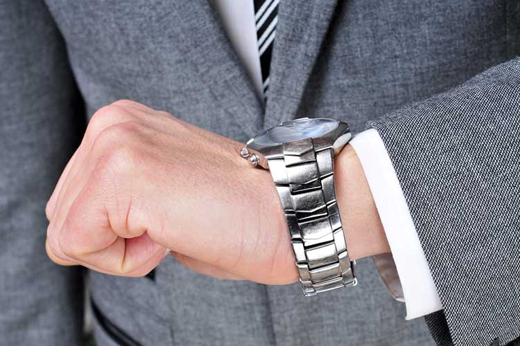 a man wearing a suit looking at his watch