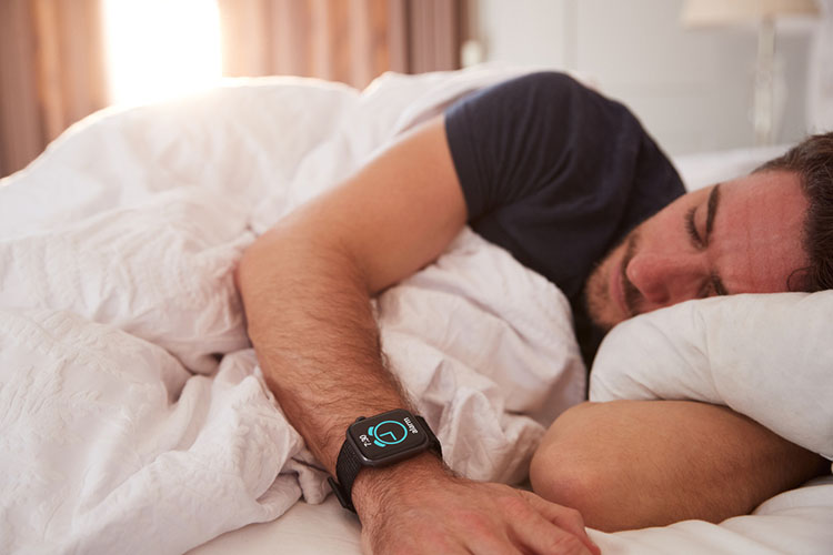 Man Asleep In Bed Wearing Smart Watch