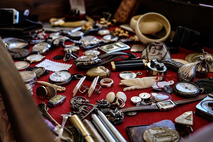 Closeup of different vintage watches and jewelry on a red surfa